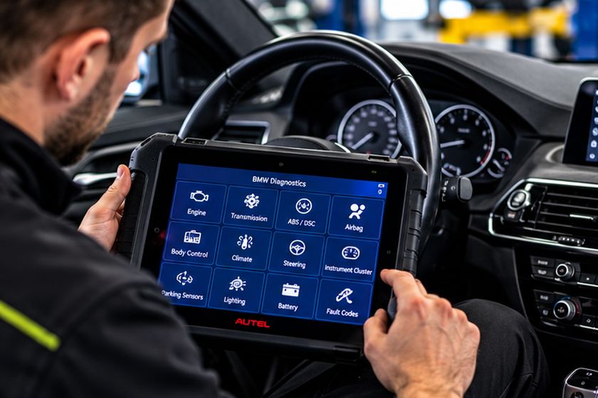 Technician using a diagnostic tablet inside a car